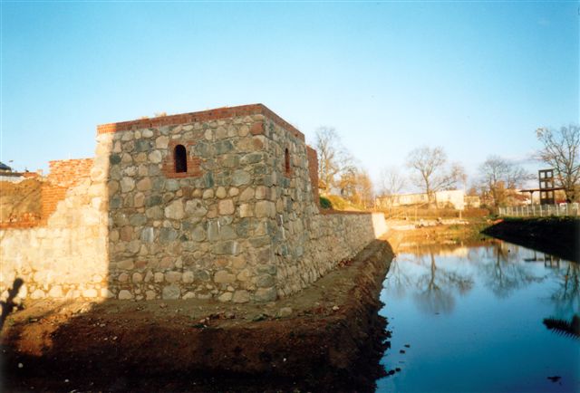 Zrekonstruowana kamienna podstawa wieży kwadratowej oraz odtworzone
podstawy kamienne murów oporowych wzgórza zamkowego. Rok 2003